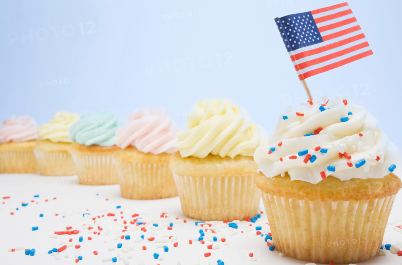 Studio shot of patriotic cup cakes with colorful sprinkles and American flag. Mendham, New Jersey, United States