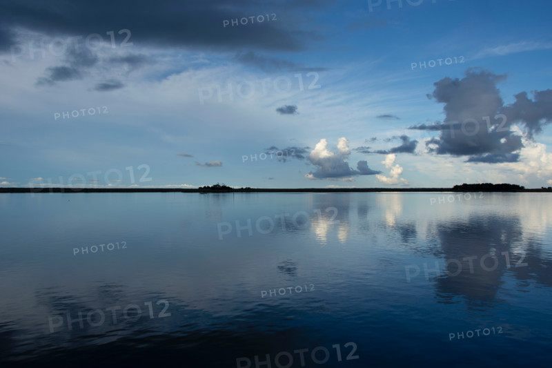 Calm surface of Apalachicola River reflecting evening sky. Apalachicola, Florida, United States