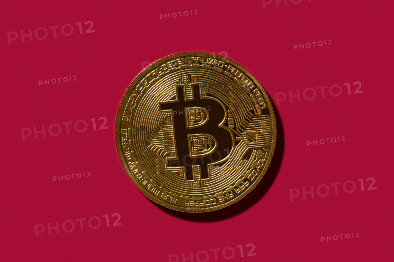 Golden Bitcoin on red background. New york City, New York State, United States