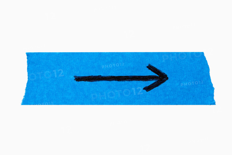Black arrow on torn blue painters tape on white background. New York City, New York State, United States