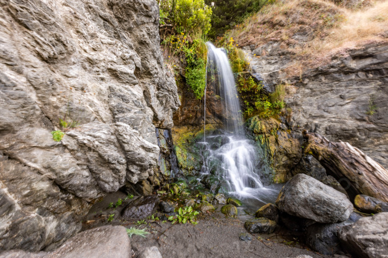 Waterfall running onto beach on Oregon Coast. Gold Beach, Oregon, United States