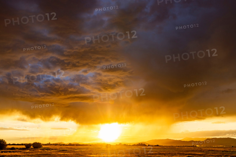 Heavy rain clouds and sun setting above landscape. Bellevue, Idaho, United States