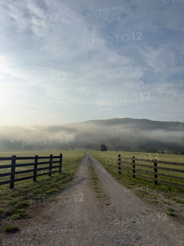 Dirt road and fields in mist at sunrise. Blacksburg, Virginia, United States