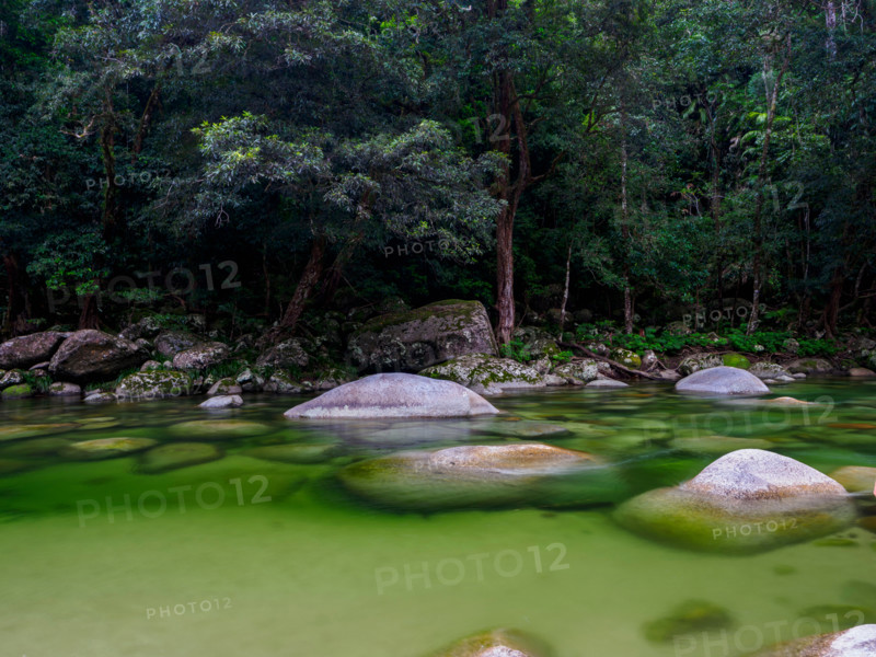Boulders in shallow green Mossman River. Mossman, Queensland, Australia