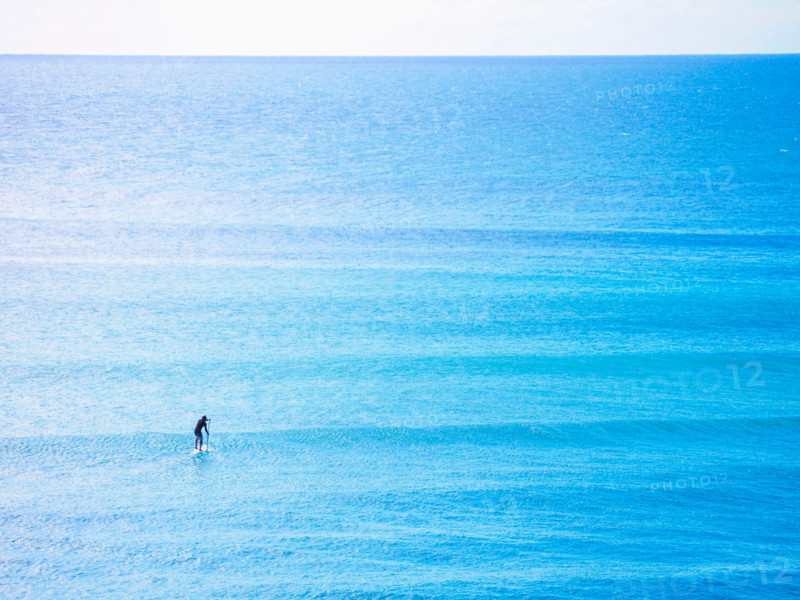 Distant paddleboarder in vast blue sea. Sunshine Coast, Queensland, Australia