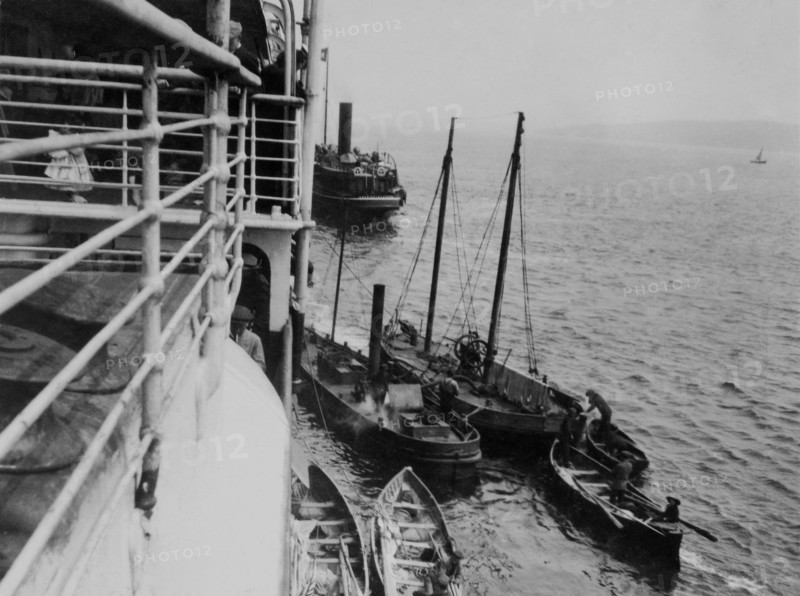 Transbordeurs et navire-citerne ravitaillant le RMS Majestic en eau douce et victuailles