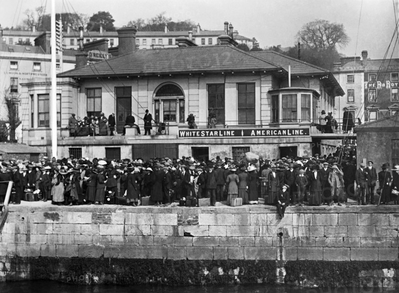 Foule de passagers attendant d’embarquer à bord d'un transbordeur, sur les quais de Queenstown en Irlande
