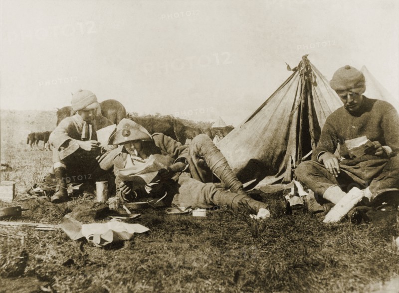 Reading letters from home. An Imperial Yeomanry serviceman, William Ernest Tweedie (right), sits outside his tent at a military camp, reading letters from home with fellow soldiers during the Second Boer War (1899-1902). Krugersdorp, Transvaal (Gauteng), South Africa, November 1900., Gauteng, South Africa, Southern Africa, Africa.