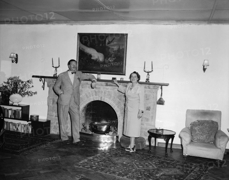 Roddy and Noreen. Roddy and his wife Noreen pose for a photograph leaning against a large fireplace in a colonial house. Taken on the christening of Peter Buchanan's baby. Nairobi, Kenya, 23 October 1954. Nairobi, Nairobi Area, Kenya, Eastern Africa, Africa.