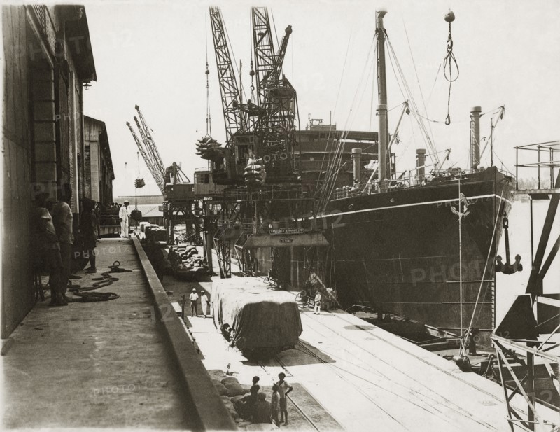 Loading grain on SS Modasa. SS Modasa docked at Kilindini harbour. Mombasa, Kenya, circa 1930. Mombasa, Coast, Kenya, Eastern Africa, Africa.