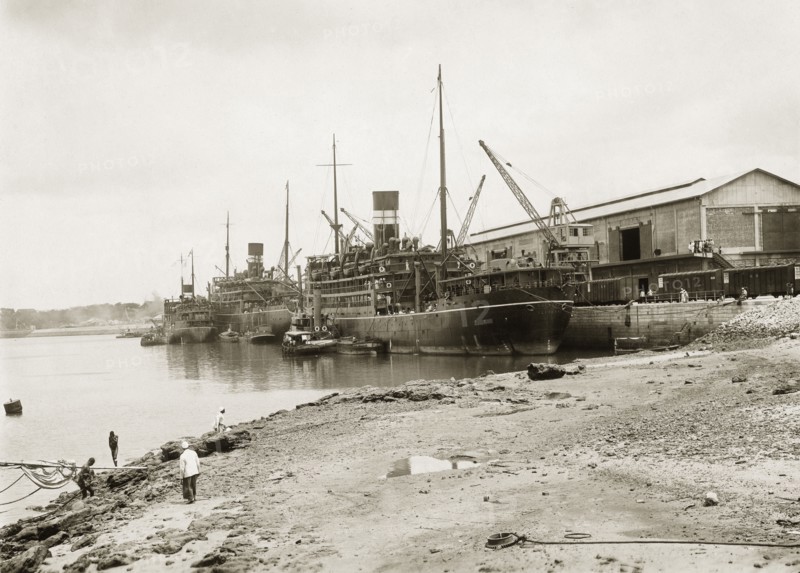 Steamers berthed at Kilindini harbour. Three near-sister cargo vessels from the British India Steam Navigation Company's fleet docked at Kilindini harbour. The ships have twin masts with a single funnel, painted in BISN's colours of black with two white bands. Mombasa, Kenya, circa 1930. Mombasa, Coast, Kenya, Eastern Africa, Africa.