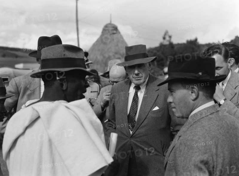 Littleton and Chief Makimei. A Western official identified as 'Littleton' talks to Chief Makemei in a crowded meeting place. Kenya, 16 May 1953. Kenya, Eastern Africa, Africa.