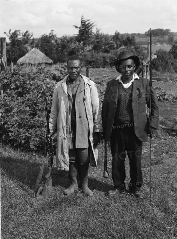 Uplands home guards. Two home guards, one armed with a rifle, the other with a club and spear. The home guard in this area consisted of Kikuyu government loyalists who independently formed militia groups to support the other British security forces present in Kenya at this time. Kenya, June 1953. Kenya, Eastern Africa, Africa.