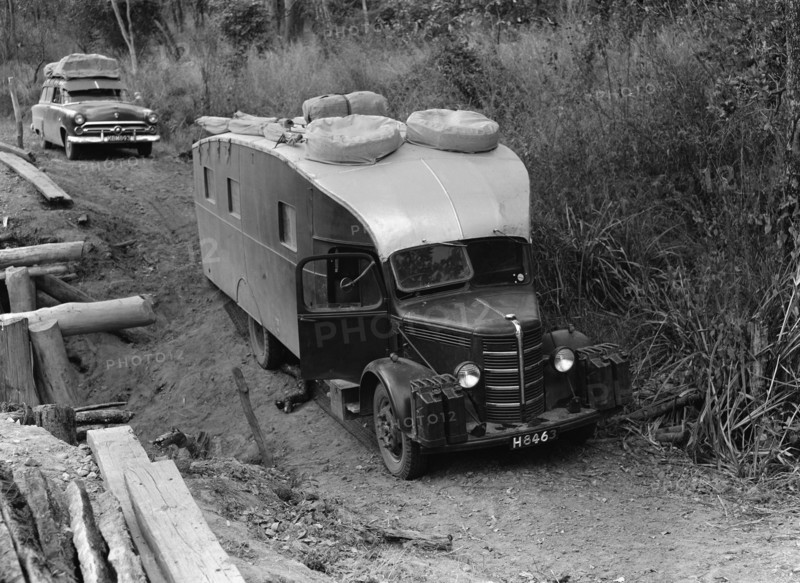 Stuck in the mud. An old-fashioned caravan is stuck on an uneven dirt path. The vehicle's registration number matches that on related photographs and belongs to the Price family. Nyasaland (Malawi), September 1953. Malawi, Southern Africa, Africa.