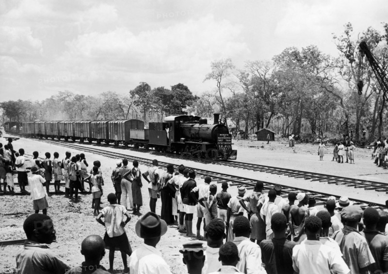 People greet the first train to Nachingwea. A publicity photograph from the East African Railways and Harbours Administration (EAR&H) shows a crowd of Tanganyikan people watching the first train from Mkwaya to Nachingwea. Tanganyika Territory (Tanzania), 25 October 1949. Tanzania, Eastern Africa, Africa.