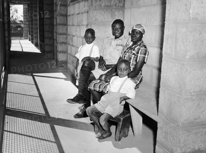 Railway family in Kenya. A publicity photograph from the East African Railways and Harbours Administration (EAR&H) showing a railway worker and his wife and two sons on the veranda of their new block of company flats. Nairobi, Kenya, circa 1960. Nairobi, Nairobi Area, Kenya, Eastern Africa, Africa.