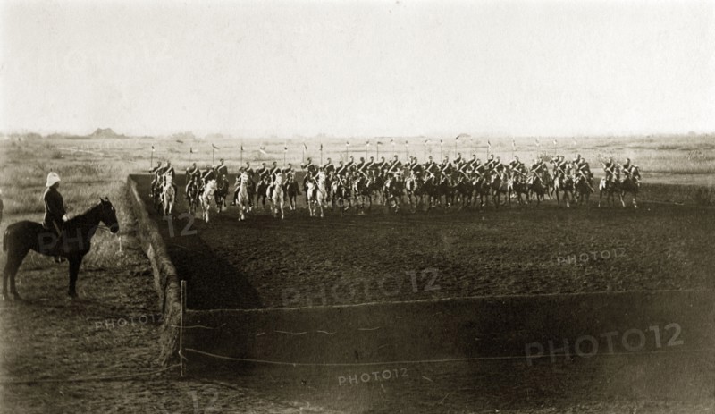 Practice cavalry charge. British men from an Indian Army cavalry unit perform a practice charge across a fenced arena with their standards raised. India, circa 1880. India, Southern Asia, Asia.