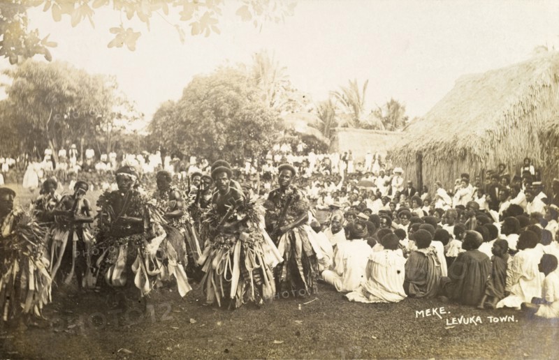 A traditional Fijian 'meke'. A crowd watches as a group of male Fijian dancers dressed in ceremonial costume perform a traditional 'meke'. Levuka, Fiji, circa 1920. Levuka, Ovalau, Fiji, Pacific Ocean, Oceania.