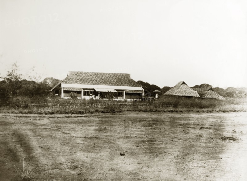Burmese dwellings. A row of single-storey, thatched roof dwellings. Burma (Myanmar), circa 1910. India, Southern Asia, Asia.