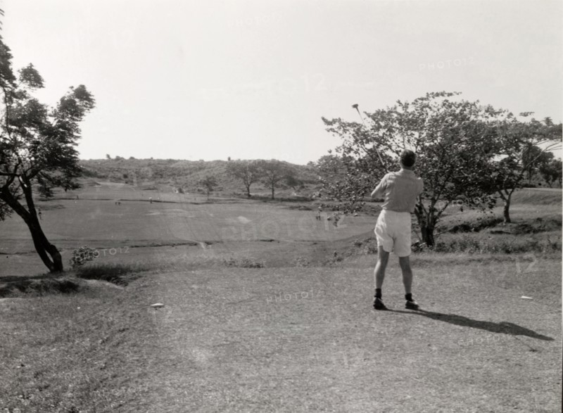 Playing golf, Rangoon. A lone golfer follows his shot, club still swung high in the air, on the course at Rangoon Golf Club. Rangoon (Yangon), Burma (Myanmar), circa 1952. Yangon, Yangon, Burma (Myanmar), South East Asia, Asia.