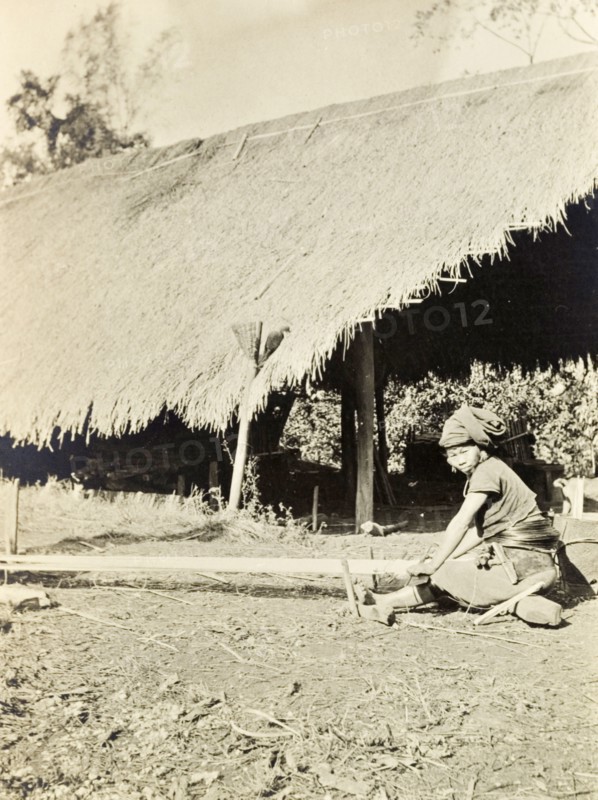 A Kachin woman weaving. A Kachin women in traditional dress weaves yarn by hand on a horizontal ground loom. Burma (Myanmar), circa 1910., Kachin, Burma (Myanmar), South East Asia, Asia.