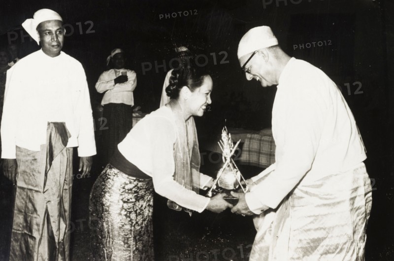 Receiving a 'Na-Ya' award. A European employer, dressed in a traditional Burmese 'longyi', is presented with a silver 'Na-Ya' award by Mrs Melvin Tun Pe. Burma (Myanmar), circa 1955. Burma (Myanmar), South East Asia, Asia.