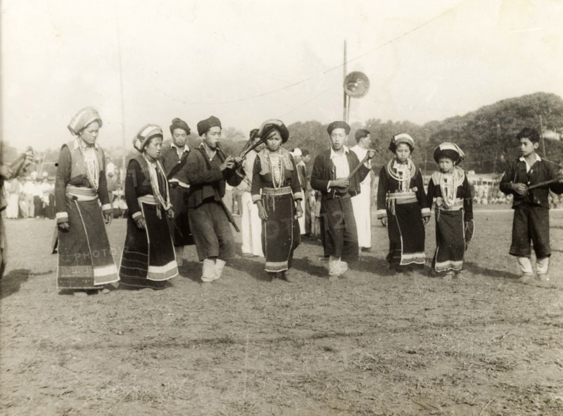 Burmese musicians. A party of Burmese musical performers in traditional dress perform at an outdoor event. The women dance to the accompaniment of wind and string instruments played by the men. Burma (Myanmar), circa 1940. Burma (Myanmar), South East Asia, Asia.