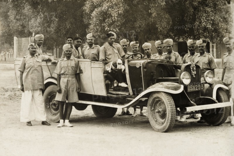 A cadre of Indian Armed Police. A cadre of uniformed Indian Armed Police assemble round a car for a photograph. India, circa 1941. India, Southern Asia, Asia.