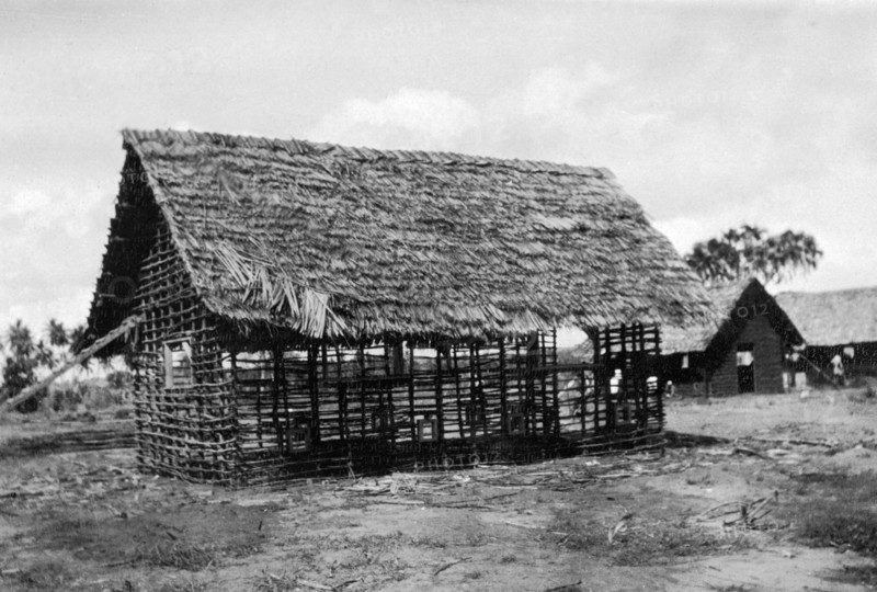 Framework for a new classroom. The timber framework and thatched roof of a classroom being built by the local employees of the Kenyan Public Works Department. Waa, Kenya, 1925. Waa, Coast, Kenya, Eastern Africa, Africa.