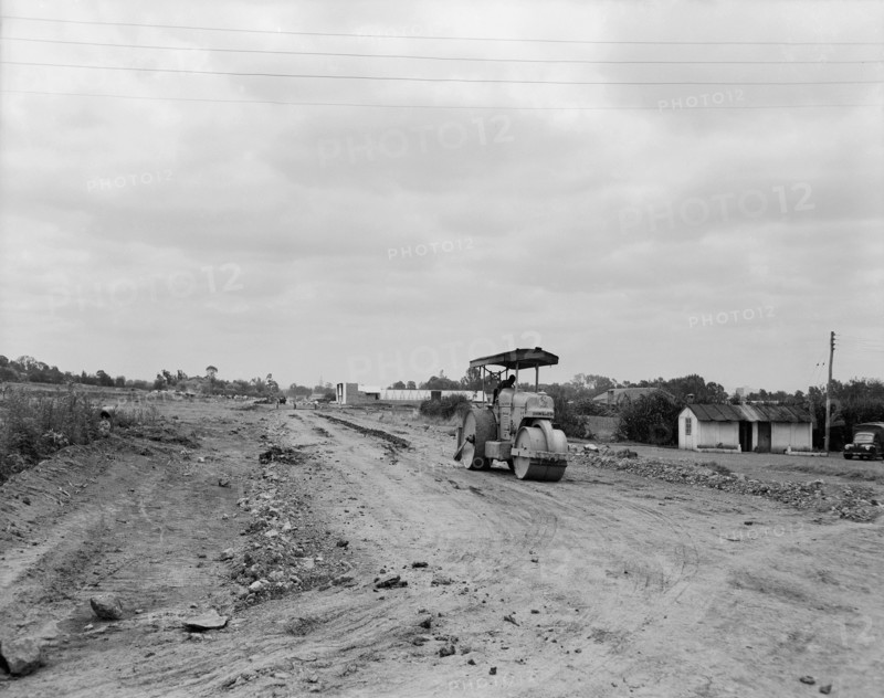 Road under construction. A lone man in a steamroller on the construction site of a new road. Kenya, 5 September 1955. Kenya, Eastern Africa, Africa.