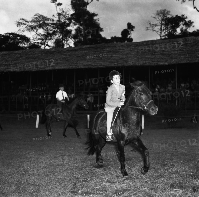 Pony competition at the SJAK show. A young girl rides a pony in the class two child's pony competition at the SJAK show (Sports Journalists Association of Kenya). Kenya, 20 August 1955. Kenya, Eastern Africa, Africa.