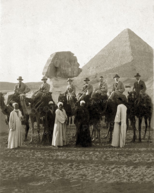 Visiting the Sphinx, circa 1924. A group of European men, probationers in the Sudan Political Service, pose for the camera on camels in front of the Sphinx and pyramids. Giza, Egypt, circa 1924. Giza, Giza, Egypt, Northern Africa, Africa.