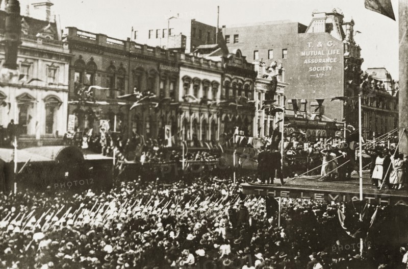 British Special Service Squadron parade. A procession of men from the British Special Service Squadron squeezes its way down Bourke Street through tightly packed crowds. Bunting festoons the road and onlookers watch from every available window and rooftop. Melbourne, Australia, 17-25 March 1924. Melbourne, Victoria, Australia, Australia, Oceania.