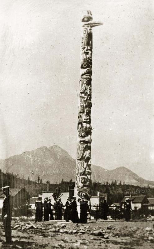 Native American totem pole. Sailors from the British Special Service Squadron stand beneath a native Amercian totem pole carved with pictograms of faces and various animals at Jasper Park. Victoria, Canada, 21 June-4 July 1924. Victoria, British Columbia, Canada, North America, North America .