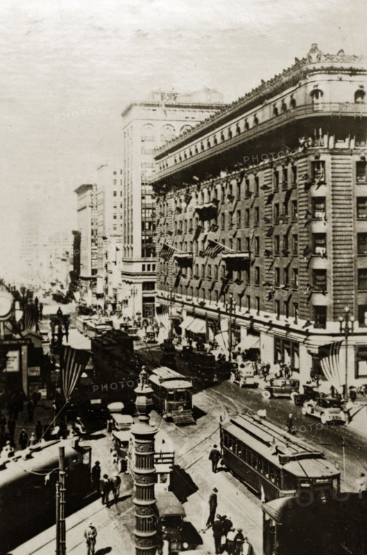 San Francisco street scene. American flags fly above a busy city street crammed with tall buildings, cars and trams. San Francisco, United States of America, 7-11 July 1924. San Francisco, California, United States of America, North America, North America .