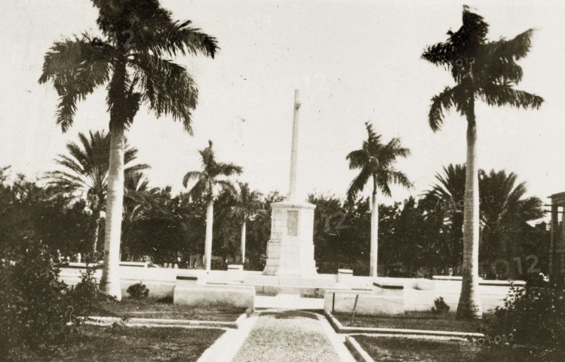 War memorial, Kingston. A war memorial stands in front of government buildings bordered by palm trees. Kingston, Jamaica, 26-30 July 1924. Kingston, Kingston, Jamaica, Caribbean, North America .