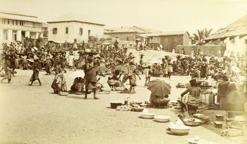 Market at Cape Coast. Street traders shelter under parasols as they sell their wares at the busy local market in Cape Coast. Cape Coast, Gold Coast (Ghana), 1917. Cape Coast, Central (Ghana), Ghana, Western Africa, Africa.