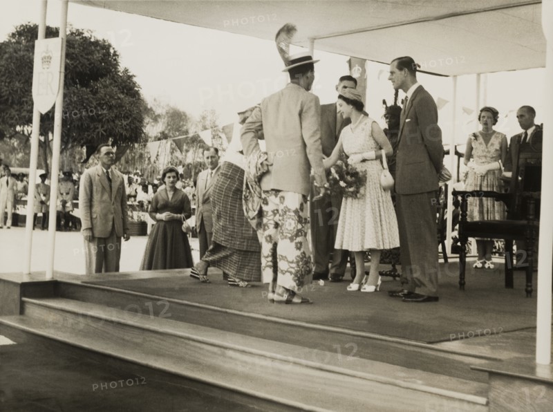 Queen Elizabeth meets a Nigerian chief. Queen Elizabeth II greets a Nigerian chief and his wife during a royal tour of Nigeria (28 January-16 February 1956). Her husband, Prince Philip, Duke of Edinburgh, stands at her side on the right. Nigeria, circa January 1956. Nigeria, Western Africa, Africa.