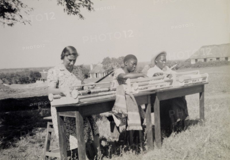 Chalimbana Training College. A European and two African women weave outdoors using hand looms at Chalimbana (teacher) Training College. Lusaka, Northern Rhodesia (Zambia), circa 1952., Lusaka, Zambia, Southern Africa, Africa.