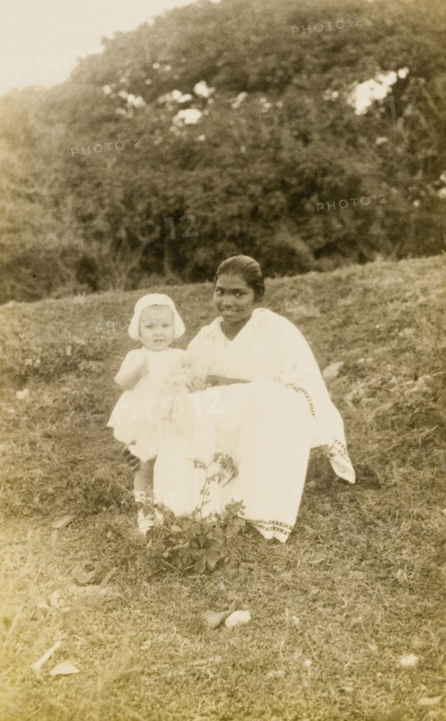 Ayah with toddler. Outdoors portrait of a young British toddler, posing for the camera with her Indian ayah (nursemaid). Bombay (Mumbai), India, 1922. Mumbai, Maharashtra, India, Southern Asia, Asia.