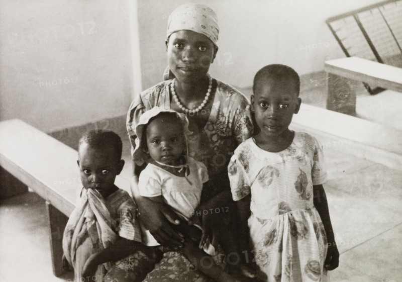 Female student of a missionary college. Portrait of an African woman with her three children, a student of a Methodist missionary college in Mombasa. Mombasa, Kenya, circa 1957. Mombasa, Coast, Kenya, Eastern Africa, Africa.