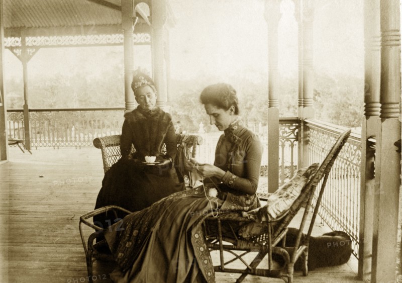 Knitting on the veranda at 'Nundora'. Informal portrait of 'Mrs Brown and Polly' taking tea and knitting on the veranda at the Brodribb's family house 'Nundora'. Toowoomba, Australia, circa 1895. Toowoomba, Queensland, Australia, Australia, Oceania.