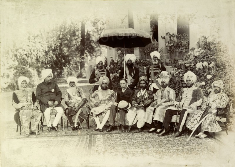 A group of Indian chiefs. A British Lieutenant Governor of the Punjab poses for a group portrait with eight Indian chiefs, his non-descript outfit contrasting sharply with the opulent dress of the Indian men. The group is accompanied by three uniformed servants, one of whom holds a parasol. Punjab, India, circa 1895., Punjab, India, Southern Asia, Asia.