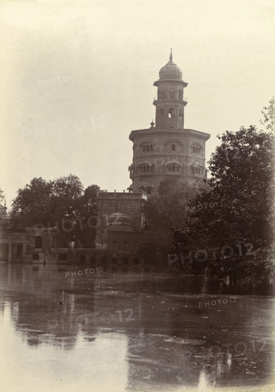 Ornate Hindu temple. An ornate Hindu temple perched on the edge of a lake is silhouetted against the sky. India, circa 1895. India, Southern Asia, Asia.