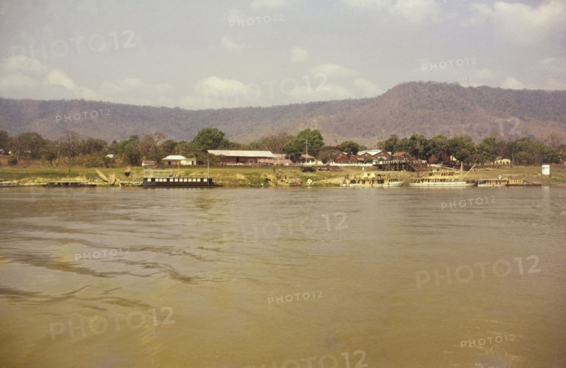Lokoja trading houses. View across the river of ferries docked beside the Royal Niger Company trading houses. Lokoja, Nigeria, circa 1965. Lokoja, Kogi, Nigeria, Western Africa, Africa.