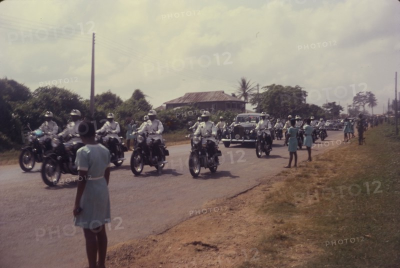 General Gowon approaches. Schoolgirls watch from a roadside as General Gowon, Head of the Federal Military Government of Nigeria, approaches in a car accompanied by a police escort. Nigeria, circa January 1970. Nigeria, Western Africa, Africa.