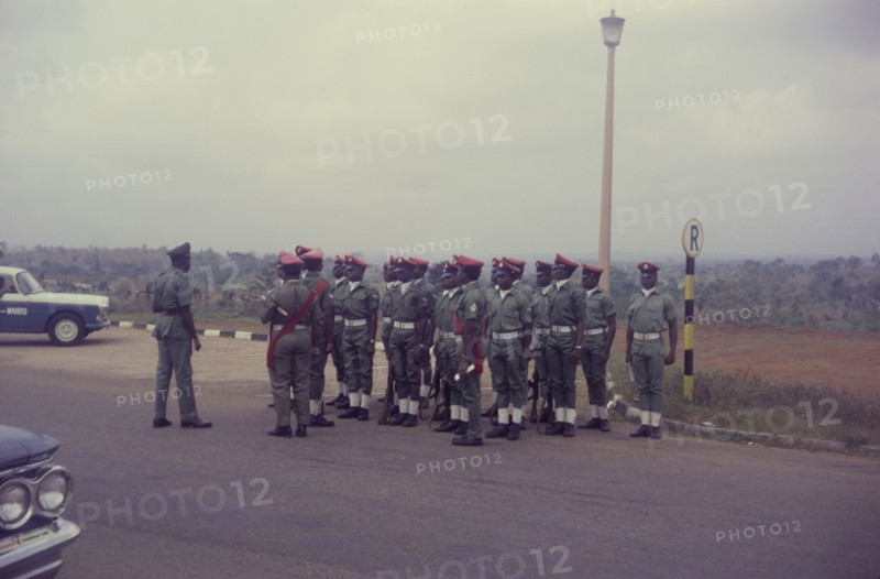Nigerian military police. Uniformed military police, pictured towards the end of the Nigerian Civil War (1967-70), stand to attention at a roadside stop. Nigeria, circa January 1970. Nigeria, Western Africa, Africa.
