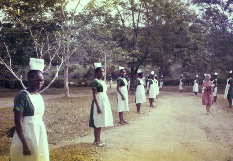 Welcome for an Archbishop. Uniformed nurses line the driveway outside a Church of Nigeria hospital, ready to welcome an Archbishop. Nigeria, February 1963. Nigeria, Western Africa, Africa.