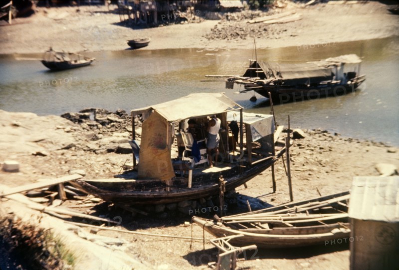 Barber's shop on a Chinese sampan. A small sampan grounded on the shore, serves as an unusual barber's shop. Tai Po, Hong Kong, People's Republic of China, August 1960. Tai Po, Hong Kong, China, People's Republic of, Eastern Asia, Asia.