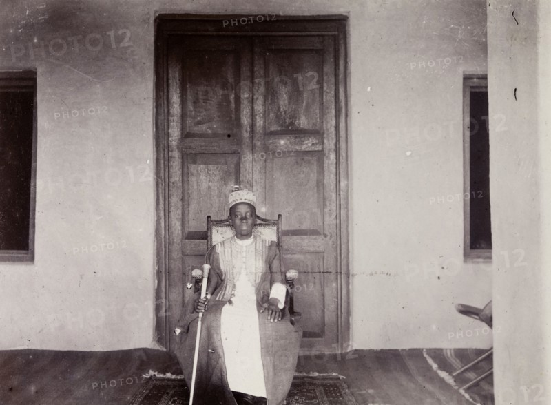 Daudi Chwa II, Kabaka of Buganda. Portrait of Daudi Chwa II, Kabaka (king) of Buganda, seated before a large doorway. Buganda, Uganda, 1906. Uganda, Eastern Africa, Africa.